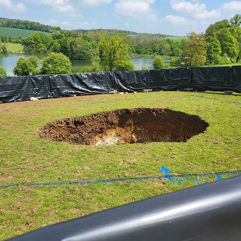 A fenced off area with a large sinkhole at its centre